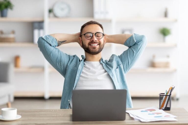 un individu souriant devant un ordinateur